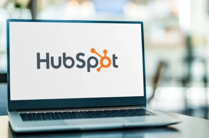 Computadora sobre escritorio con logo de HubSpot 